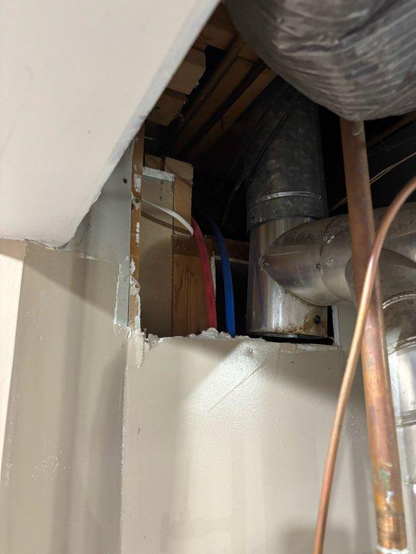 Responded to investigate tapping noise occurring when hot water was activated in upstairs bathroom. Inspected utility room where PEX water lines were accessible through exposed wall opening. Identified unsecured PEX hot water lines as the source of the tapping sound. Repositioned and secured the loose PEX piping within the wall cavity. Verified tapping noise ceased after adjustment. Recommended insulating the hot water line if noise recurs in the future to prevent thermal expansion sounds.