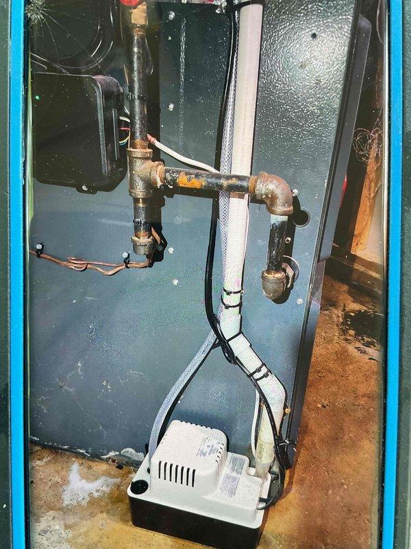 Responded to leaking drain issue caused by clogged condensate line resulting in water backup into furnace heat exchanger. Cleared drain line obstruction and installed new condensate pump with drain line to prevent future drainage failures. Upon inspection, evaporator coil pitch was found to be adequate; blockage was the primary cause of system flooding and furnace cabinet water damage.