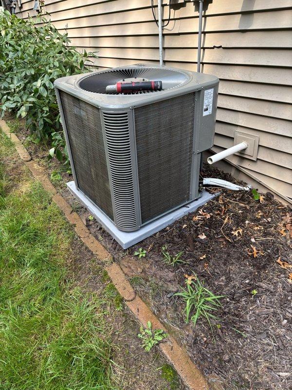 Completed comprehensive AC maintenance on residential split system. Cleaned heavily obstructed condenser coils that were plugged with grass clippings and lawn debris. Inspected and verified proper operation of contactor and capacitor. Advised homeowner to set filter change reminders on thermostat and requested lawn maintenance personnel redirect mower discharge away from outdoor unit to prevent future coil blockage. System operating within normal parameters with no deficiencies identified.