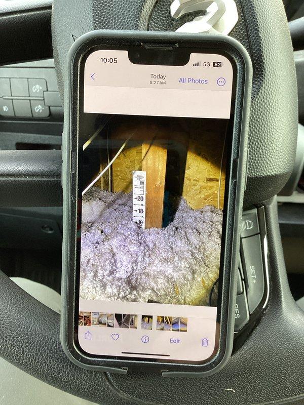 Responded to callback for recently installed 2.5 ton AC system not maintaining desired temperature. Verified system operation, blower speeds, evaporator coil condition, and air filter—all found functioning within normal parameters. Identified contributing factors including portable AC unit running upstairs with house already above setpoint, and basement room with powered ventilation creating negative pressure in home. Negative pressure was drawing conditioned air out through passive intake in mechanical room, significantly impacting system efficiency. Recommended sealing off room containing powered vent and providing dedicated passive air intake for that space to eliminate negative pressure issue. Suggested relocating portable AC unit to problem room for supplemental temperature control if needed. Documented attic insulation and system conditions with photos.