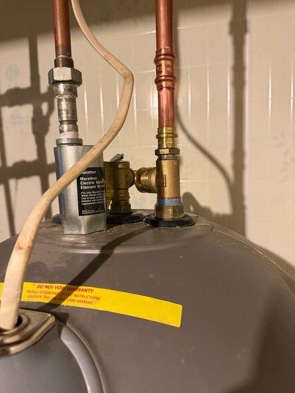 Installed vacuum relief tee on Rheem Marathon water heater to prevent thermal expansion issues and protect the tank from potential vacuum conditions. The brass fitting was integrated into the existing copper piping system at the top of the unit, ensuring proper venting and compliance with plumbing code requirements.