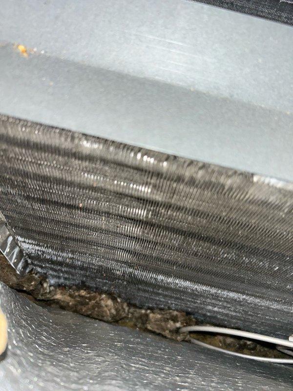Completed annual AC tune-up and system performance check on residential air conditioning unit. Outdoor condenser coil was heavily impacted with dirt and debris, restricting airflow, and was thoroughly cleaned during service. Return air filter was heavily loaded with particulate buildup and replaced with new filter. 

Upon inspection, evaporator coil displayed significant buildup and debris accumulation along fins and surfaces, reducing heat transfer efficiency and restricting airflow across the coil. Documented condition with photographs showing contamination at coil base and ductwork seams. Recommended professional evaporator coil cleaning to restore optimal system performance and efficiency.

Outdoor contactor exhibited visible wear, pitting on contact surfaces, and electrical degradation indicating imminent failure risk. Recommended contactor replacement to prevent system shutdown and ensure reliable operation during peak cooling season.
