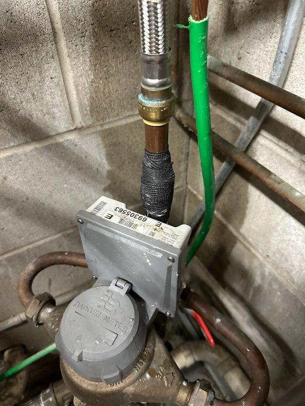 Responded to a water leak issue caused by a pinhole in the copper pipe located directly above the water meter. The customer had previously applied a temporary patch but requested a permanent repair. Upon inspection, confirmed the pinhole leak in the copper piping and proceeded with cutting out the damaged section. Installed new copper pipe section using appropriate fittings and soldered connections to ensure a watertight seal. Tested the repair under normal water pressure to verify no leaks were present. The water supply remained operational throughout the service, requiring only brief shutoff during the pipe replacement. All work was completed to code standards with proper support and securing of the new pipe section.