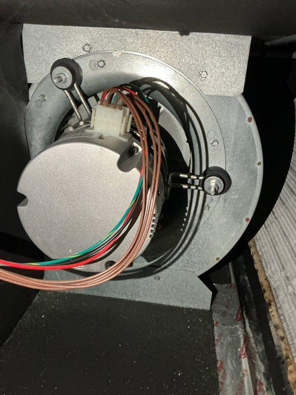 # HVAC Maintenance Completed

Performed annual cooling system maintenance on a 6-year-old Unico air conditioning unit as part of a recurring preventive maintenance agreement. Conducted comprehensive tune-up including inspection of blower motor assembly, electrical connections, and evaporator coil. Verified all colored wiring connections at motor housing were secure and properly terminated. Inspected finned heat exchanger coil and noted dust and debris accumulation on aluminum fins, which is typical for seasonal operation. Checked blower housing mounting hardware and confirmed secure installation. Verified drainage pan condition and inspected surrounding mechanical components. All system components tested and operating within normal parameters with no deficiencies requiring immediate attention. Unit functioning properly upon completion of service visit.