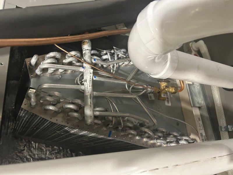 Responded to no cooling complaint on 2-year-old Lennox system displaying error codes 00a8 and 00c1 with reported evaporator coil freeze-up and water leakage under furnace. Upon arrival, system was operating normally with adequate cooling and coil was thawed. Verified air filter and condenser coil were clean per homeowner maintenance. Connected manifold gauges and placed unit in charge mode for diagnostic testing. Confirmed refrigerant pressures and temperatures within manufacturer specifications for 2-ton system. Verified high cooling airflow was properly configured. Adjusted system airflow settings to optimize performance: increased low cooling airflow CFM, increased dehumidification mode airflow, and increased continuous fan speed to address reported weak airflow. System tested successfully with proper operation and no freeze-up conditions observed at completion.