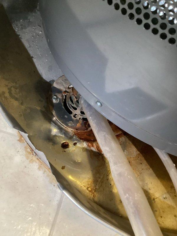 Responded to service call for 4-year-old Rheem Classic Pro gas water heater with visible leaking from drain pan. Upon inspection, found compromised drain pan with rusted floor drain hose and deteriorated water retention capacity. Drain pan was also receiving condensate discharge from HVAC system, contributing to overflow condition. Relocated water heater unit and installed new drain pan with proper drainage connections to accommodate both water heater discharge and HVAC condensate lines, restoring proper containment and drainage functionality.