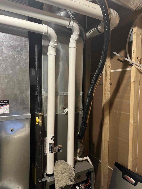 Responded to report of water dripping from furnace intake vent. Upon inspection, identified condensation forming inside the intake pipe due to temperature differential between warmer outdoor air and cooler indoor conditions. Documented findings with photos showing PVC intake piping configuration and surrounding HVAC components. Generated order form for drain kit installation to resolve condensation issue and prevent future water intrusion into the intake system.