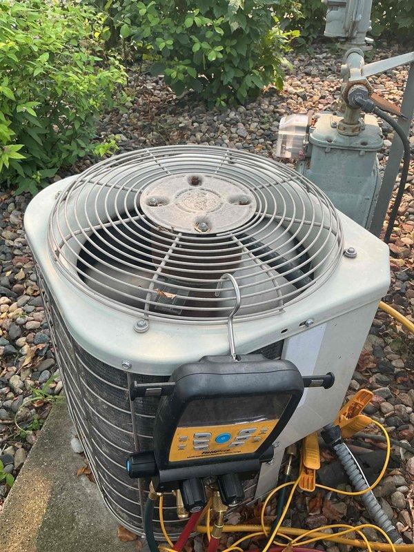 Responded to no cooling complaint on 30-year-old residential air conditioning system. Upon diagnosis, found system critically low on obsolete R22 refrigerant, causing evaporator coil to freeze and resulting in water leakage onto furnace below. Outdoor condenser coils showed significant dirt accumulation from lack of maintenance history. Connected manifold gauges to verify low refrigerant charge and confirmed frozen indoor coil condition. Due to age of system, obsolete refrigerant type, and cost-prohibitive nature of R22 recharge, recommended complete system replacement rather than temporary repair. Scheduled follow-up estimate appointment for new air conditioning system installation.