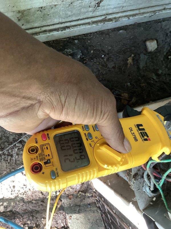 Performed HVAC maintenance and inspection on residential system. Upon arrival, system was operational but required routine tune-up and cleaning as requested. During comprehensive evaluation, discovered refrigerant charge was low and condenser unit sustained significant damage. Documented system conditions with diagnostic readings showing 298 on electrical testing equipment. Assessed refrigerant lines and connections in outdoor installation area. Due to extent of condenser damage, recommended full condenser unit replacement rather than repair to ensure system reliability and efficiency.