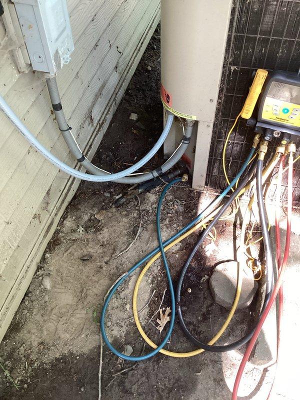 Performed HVAC maintenance and inspection on residential system. Upon arrival, system was operational but required routine tune-up and cleaning as requested. During comprehensive evaluation, discovered refrigerant charge was low and condenser unit sustained significant damage. Documented system conditions with diagnostic readings showing 298 on electrical testing equipment. Assessed refrigerant lines and connections in outdoor installation area. Due to extent of condenser damage, recommended full condenser unit replacement rather than repair to ensure system reliability and efficiency.