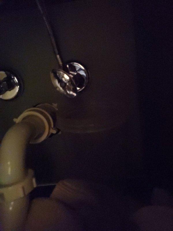Responded to emergency water leak under bathroom vanity with water pooling and main shut-off valve inoperative. Diagnosed failed angle stop under sink and defective main water shut-off valve. Replaced main shut-off valve to restore water control to property and installed new angle stop under bathroom sink, resolving all active leaks.