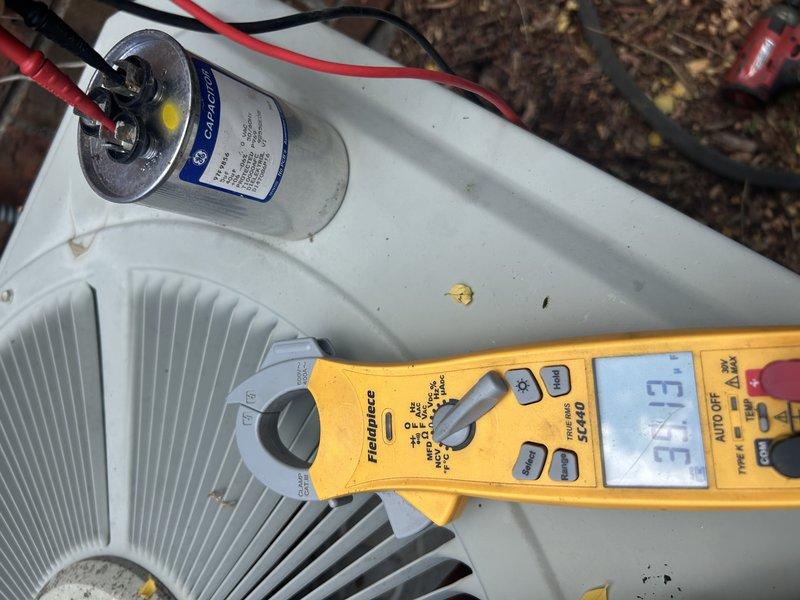 Responded to no cooling call on 25-year-old residential air conditioning system. Diagnosed indoor blower motor failing to maintain operation due to defective run capacitor testing at 8 out of 10 microfarads. Replaced failed capacitor, installed new air filter, and performed condenser coil cleaning to restore system functionality. System returned to normal operation with adequate airflow and cooling capacity. Noted system appears overcharged but has operated in this condition since installation without issue. Identified damaged section of condensate drain line requiring future repair and provided replacement pricing to customer.