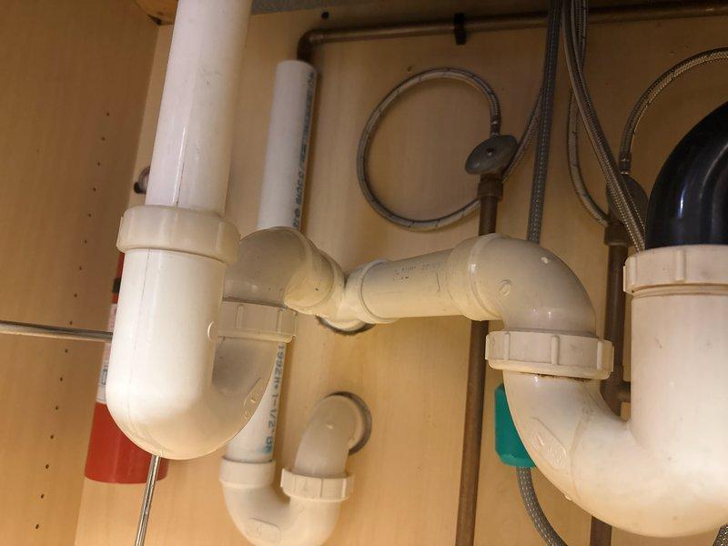 Completed kitchen sink conversion from dual-basin to single-basin configuration. Reconnected kitchen drain plumbing using PVC P-trap assembly, ensuring proper alignment and secure connections to vertical drain lines. Verified garbage disposal unit connections, water supply lines, and tested system for proper drainage and leak-free operation.