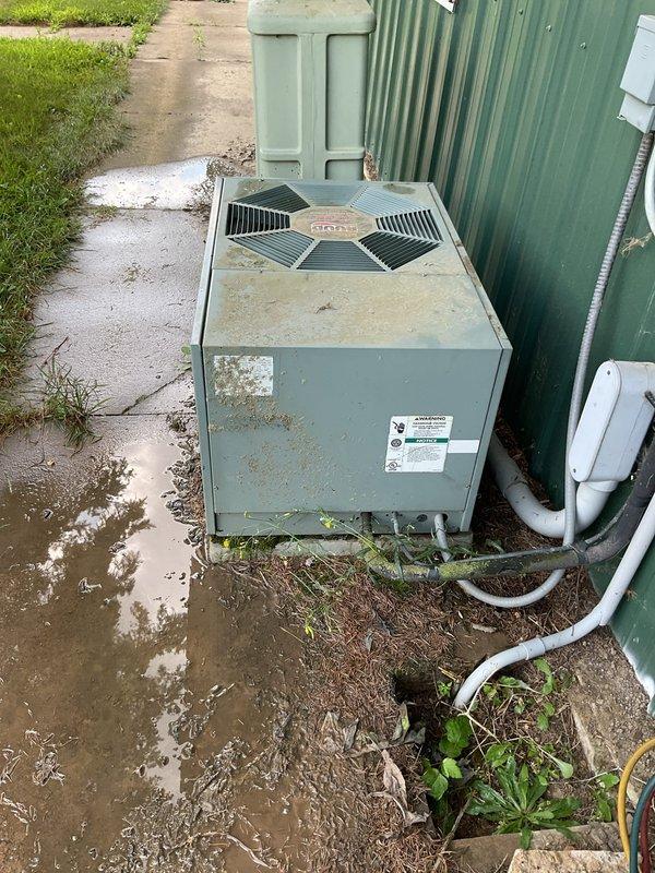 Responded to no cooling complaint at main office with two units down. The newer 23-year-old unit was off upon arrival; restarted unit and performed condenser coil cleaning due to heavy dirt accumulation. Unit operational after cleaning but noted possible low refrigerant charge and fan motor wobble requiring future attention. The second unit, approximately 60+ years old and severely deteriorated, was tested with new capacitor replacement but failed to maintain operation after brief runtime. Recommended complete replacement of older unit due to age and condition.