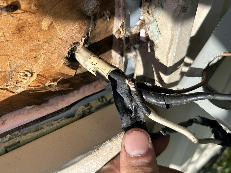 Responded to no cooling complaint on central air conditioning system. Upon inspection, found blown fuses and damaged, mangled disconnect at outdoor unit. Identified damaged wiring as contributing factor to fuse failure. Temporarily bypassed faulty disconnect to continue diagnostics. Circuit breaker continued to trip after bypass, indicating additional electrical fault. Performed amp draw testing and diagnostics on compressor, which revealed compressor failure causing breaker to trip. Documented damaged electrical components with photos showing deteriorated wire insulation and compromised connections. Provided pricing options for compressor replacement. System remains inoperable pending approval from property owner, as occupants are in rent-to-own agreement and require owner authorization before proceeding with repairs.