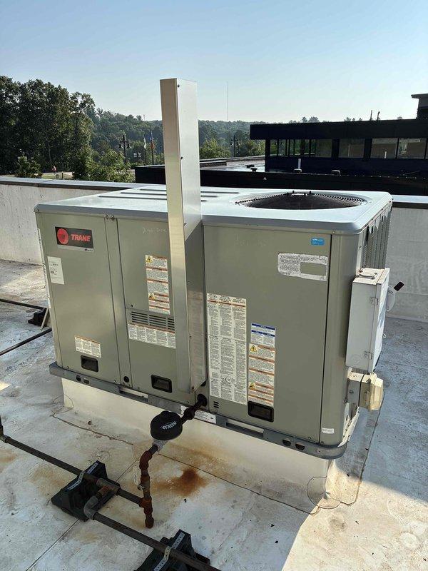 Responded to callback for kitchen RTU not maintaining temperature. Upon inspection, discovered microchannel condenser coil severely plugged with cottonwood debris that was not visible from external view. Purged condenser coil with nitrogen to remove blockage, significantly improving airflow and visibility through coil fins. Unit cooling performance restored and should now maintain setpoint effectively. Noted all rooftop units at location show similar condenser fouling and will require thorough coil cleaning during next scheduled visit for smoke detector service.