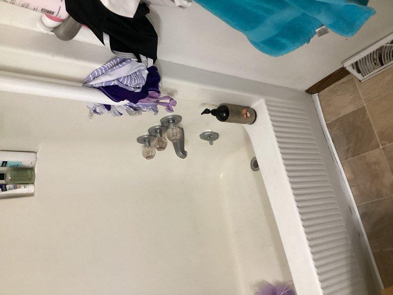 Responded to service call for shower head leaking behind wall. Upon inspection, identified the shower arm as the source of the leak. Although additional potential leaks were observed at the tub spout and tub drain overflow assembly, the customer requested repair limited to the shower arm only. Successfully removed the defective shower arm and installed a new replacement unit, ensuring proper thread seal and secure connection to the water supply line. Verified no active leaks at the shower arm connection point upon completion and restored full shower functionality.