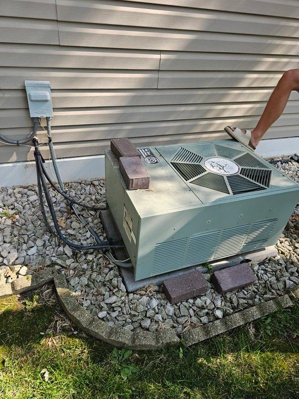 Responded to no cool call on 30-year-old A/C system with water condensation buildup in drain pan. Inspected air filter (satisfactory), evaporator coil, and drainage system (clear). Heat exchanger inspection revealed cracks and significant rust accumulation. Outdoor unit evaluation identified low refrigerant charge. Cleaned condenser coils and verified electrical components operational. System currently running with undercharge; advised homeowner of potential ice buildup recurrence and system age-related concerns requiring future attention.