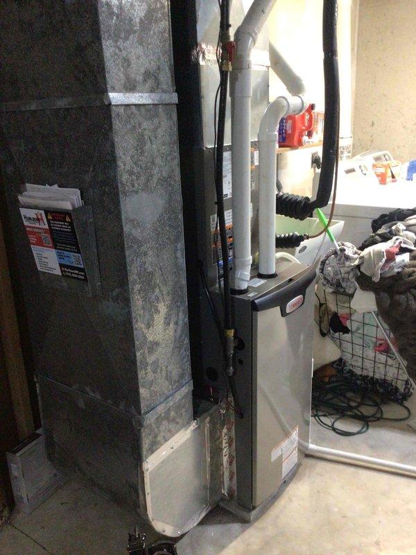 Responded to callback for water accumulation under recently installed furnace and moisture spots on basement drywall. Upon inspection, found no leaks from HVAC system components or condensate lines. Investigation revealed failed sealant around lineset penetration at exterior wall, allowing rainwater infiltration. Water traveled through lineset insulation and dripped at furnace location. Removed old silicone and properly sealed exterior penetration to prevent further water intrusion.