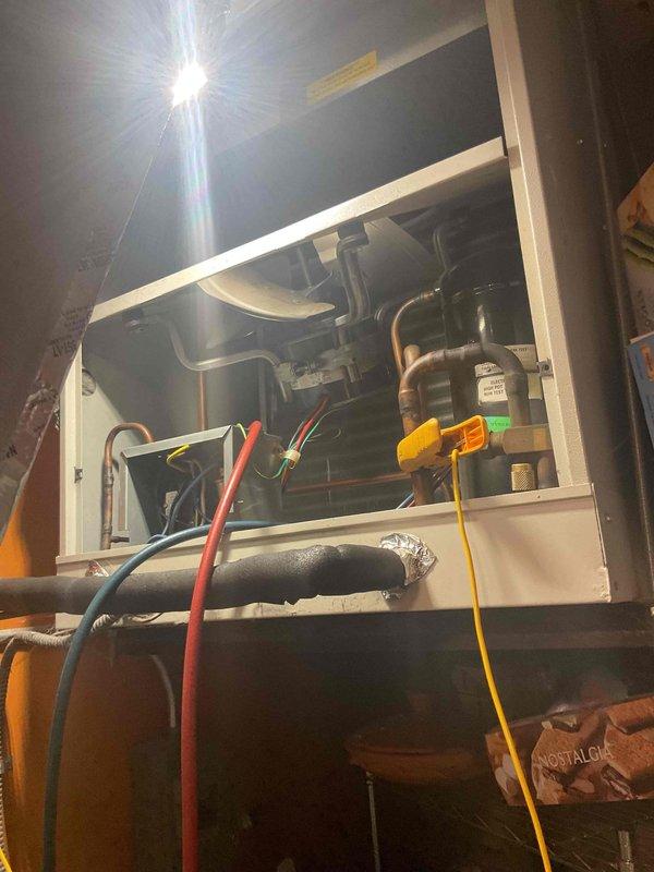 # HVAC Service Report - No Cooling Issue

Responded to a no-cooling complaint on a Carrier air conditioning system over 10 years old at a rental property. Upon arrival, confirmed the unit was running but not producing cool air. Performed diagnostic testing on the system using electrical test equipment to measure operational parameters and identify the root cause of the cooling failure.

Removed the front access panel of the indoor air handler to inspect internal components including the evaporator coil, refrigerant lines, and associated mechanical assemblies. Connected diagnostic leads to measure voltage, amperage, and system performance. Inspected copper refrigerant tubing, insulated suction lines, and internal pump/motor components for signs of failure or degradation.

Given the advanced age of the Carrier unit and the nature of the cooling failure, evaluated whether repair or replacement would be the most appropriate course of action. Documented the system condition through photogra