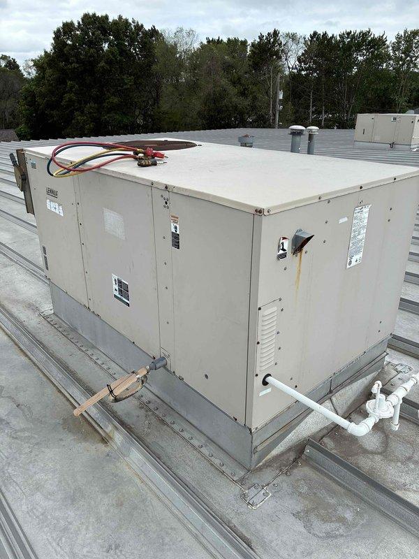 Responded to callback for RTU Unit 10 experiencing recurring no cool conditions. Upon arrival, thermostat was satisfied but staff reported inadequate cooling during peak heat hours following recent blower service. Inspected rooftop unit and found it running with excessive condensate discharge. Blower assembly operating properly with no freeze-up conditions present. Discovered only one stage of cooling operational with high pressure safety switch tripped on circuit 1 compressor. Reset high pressure switch and monitored system operation for 20 minutes, confirming both cooling stages functioning correctly. Verified 3-degree temperature drop in showroom during test period. Condenser coil airflow appeared adequate at time of service. Recommended monitoring system performance and potential condenser coil cleaning if cooling issues persist.