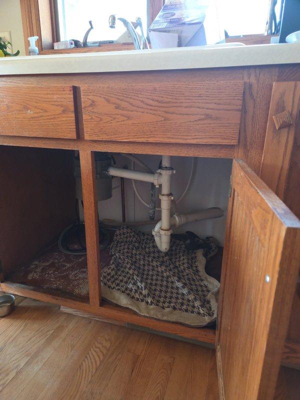 Responded to kitchen sink leak with water pooling on floor. Upon inspection, found P-trap clogged and compression drain fitting gaskets failing, causing water to discharge from drain assembly when faucet was operated. Cleared obstruction from trap, replaced deteriorated gaskets, and installed new sections of drain pipe beneath sink to restore proper drainage and eliminate leaks. Additionally, cleared blockage from cold water side of laundry sink to restore full water flow. Cleaned work area, tested all fixtures for proper operation, and confirmed no active leaks present upon completion.