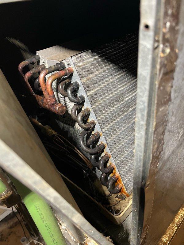Responded to water leak in basement originating from central air conditioning system above furnace. Diagnosed plugged condensate drain line as primary cause of water overflow. Cleared blockage from evaporator coil condensate line and verified proper drainage from drain pan. Replaced heavily soiled air filter. Inspected outdoor condensing unit and confirmed all components operating within manufacturer specifications, noting age-related wear on select components. Performed operational test of complete AC system for 15 minutes, verified 16-18 degree temperature split across evaporator coil, and confirmed system functioning properly with no further leakage.