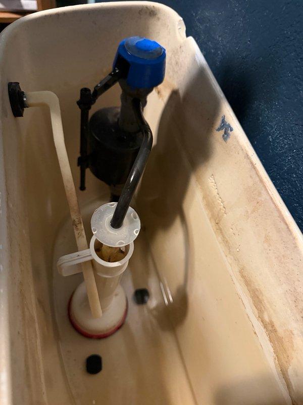 Responded to a continuously running toilet that would get stuck after flushing. Upon inspection, identified a broken trip lever stop on the fill valve preventing proper shutoff. Replaced the damaged trip lever stop and installed a new flush valve gasket to ensure proper sealing and operation. Tested the flush mechanism to verify the toilet now cycles correctly without continuous running.