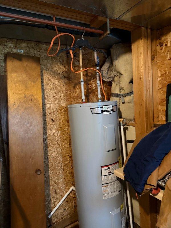 Completed warranty replacement of electric water heater in unfinished basement utility area. Removed failed unit and installed new water heater, including all necessary connections to existing copper supply lines and electrical service. Installation included proper connection of temperature and pressure relief valve, securing all hot and cold water connections, and disposal of old unit per manufacturer warranty requirements.