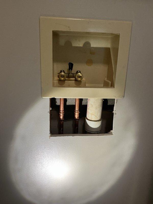 Responded to a water leak issue involving malfunctioning washing machine shut-off valves that failed to completely stop water flow. Removed the deteriorated dual shut-off valve assembly showing significant rust and corrosion on threaded connections. Installed new brass dual-handle shut-off valve with proper sealing, restored water supply, and verified all connections were secure with no leaks present upon completion.