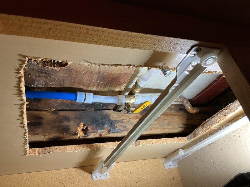 Responded to a water leak behind shower originating from cold water supply line. This location had previously experienced a hot water leak that was repaired approximately one year ago. Accessed the plumbing system through ceiling and wall openings to locate and assess the leak source. Identified failed section of cold water piping requiring replacement. Removed compromised piping section and installed new piping with appropriate fittings and connections using PEX and brass connectors. Verified all connections were secure and tested system for proper operation and absence of leaks. Evidence of previous moisture exposure was visible on surrounding wooden framing from prior leak incident.