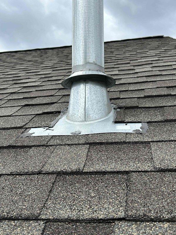 Performed return visit to investigate reported moisture leaking from roof around furnace vent pipe. Conducted thorough inspection of roof penetration and flashing, then performed water test by hosing down the vent pipe while monitoring for leaks. No active dripping was observed during testing, and pipe sealing appeared intact. Documented findings with photos of the galvanized vent stack and flashing assembly, noting weathered sealant condition. Forwarded information to install department with recommendation for follow-up visit in spring when roof is dry to reseal flashing and verify attic interior conditions.