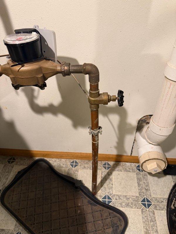 Replaced malfunctioning gate valve with 1" ball valve ahead of water meter. The existing gate valve was inoperable and failed to shut off water supply, which was discovered when city technicians replaced the water meter and had to use the curb valve at the street instead. Installed new ball valve on copper piping to provide reliable shut-off capability for future maintenance and emergency situations. System tested and verified proper operation of new shut-off valve.