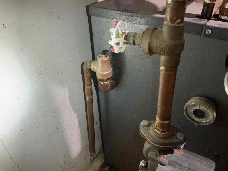 Performed comprehensive pre-sale inspection on 30+ year old Weil McLain boiler system. Found system low on water with circulator pump exhibiting cavitation sounds due to low water condition. Identified slow leak at air separator and evidence of water leak on heat exchanger exterior. Conducted combustion analysis which confirmed safe burning operation with proper gas-to-air mixture. Verified heat exchanger seals are maintaining integrity and containing combustion gases without spillage. Tested and confirmed backflow preventer, expansion tank, and system controls are functioning within acceptable parameters. Documented copper piping deterioration above unit showing oxidation and corrosion with active leak causing rust formation on boiler exterior. Completed certification letter detailing system condition and safety status for real estate transaction.