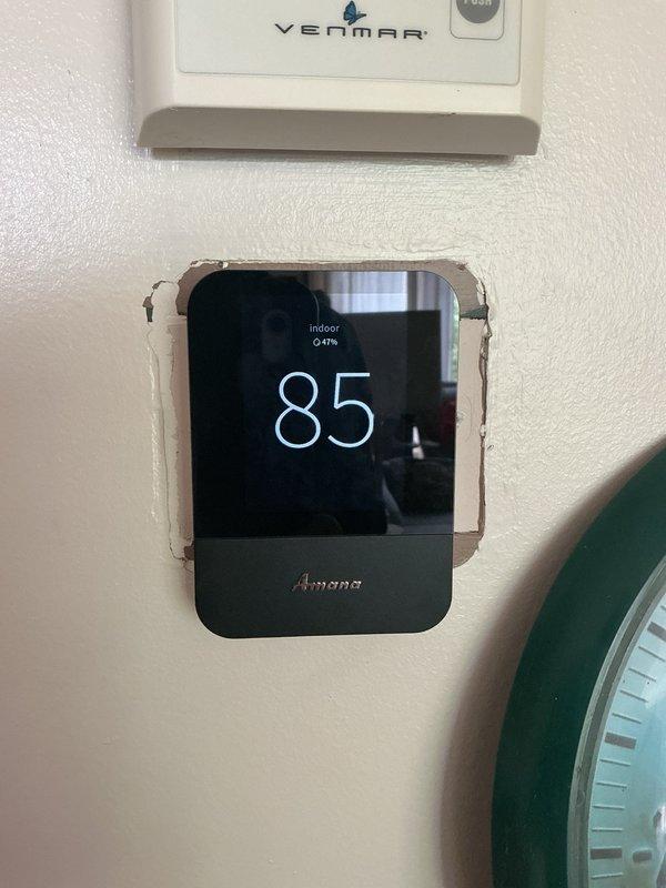 Responded to service call for Amana heat pump system with thermostat displaying inaccurate temperature readings. Upon arrival, found thermostat reading 84°F while actual room temperature was 79°F, a +5°F discrepancy. Noted multiple additional thermostats mounted in close proximity to the HVAC thermostat on the wall, which may have contributed to confusion. Accessed thermostat settings menu and performed calibration adjustment to correct the temperature offset. Verified accurate temperature display and provided instruction on proper thermostat calibration procedures. System confirmed operational with corrected temperature readings.