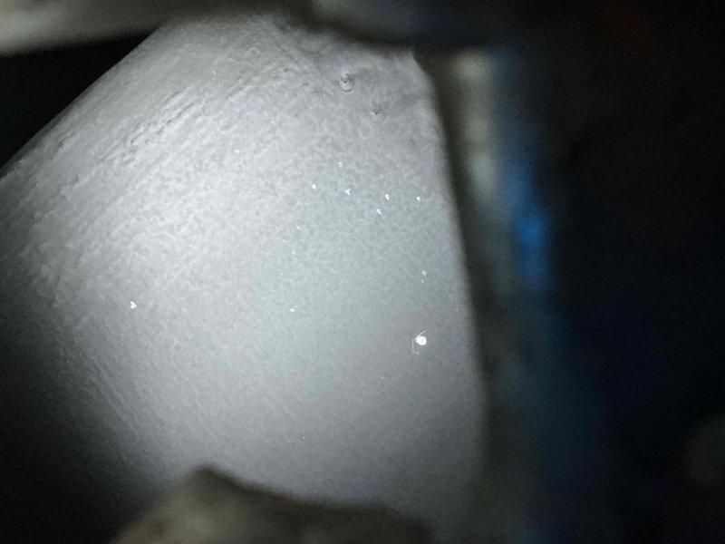 Responded to no cooling call on aging HVAC system where evaporator coil was completely iced over and compressor was running. Found furnace blower not functioning, which prevented proper airflow through the system and caused the freeze-up. Documented condensation on refrigerant lines and iced coil condition with photos. Advised system shutdown to allow ice to melt completely before further diagnosis, as frozen coil prevents accurate assessment of underlying issues with the 40-50 year old furnace blower motor and overall system operation.