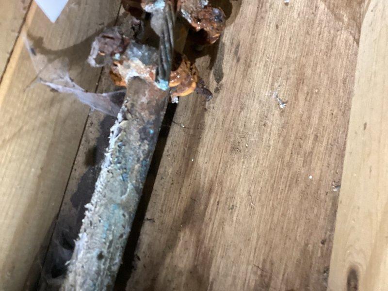 Responded to water leak at meter service valve. Upon inspection, identified heavily corroded and deteriorating service valve before the water meter with active leakage. Valve exhibited significant rust, mineral deposits, and oxidation indicating prolonged moisture exposure and age-related failure. Documented existing conditions with photographs showing the corroded valve assembly within wooden framing near water heater location. Provided detailed estimate for replacement of the defective service valve before the meter to stop the leak and restore proper function. Customer was informed of repair options and associated costs.