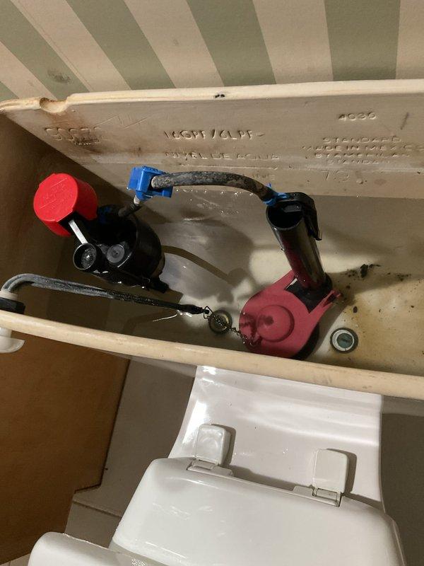 Responded to toilet tank leak caused by improper alignment between tank and bowl. Removed existing tank-to-bowl hardware and inspected mounting surfaces for damage. Installed American Standard EZ Install Tank-to-Bowl Kit including new gasket, mounting bolts, washers, and rubber grommets to ensure proper seal and alignment. Rebuilt internal tank components including flapper valve and fill valve assembly. Tested flush mechanism multiple times to verify leak elimination and proper tank-to-bowl connection.