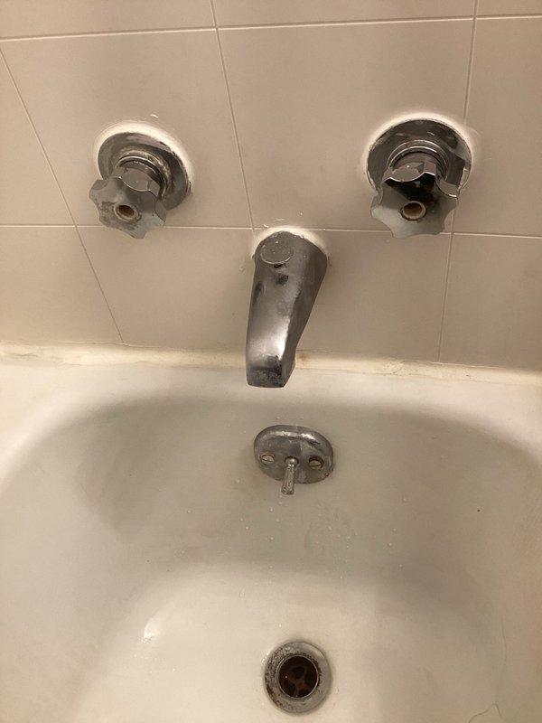 Responded to service call for malfunctioning shower fixture in unit 201. Upon inspection, identified worn cartridge in older model tub/shower valve assembly requiring replacement. Due to age of fixture and specialized Belgian-manufactured components, determined that cartridge would need to be special ordered. Documented existing three-valve configuration with chrome handles and spout showing mineral buildup and wear. Submitted parts order request and provided repair estimate for cartridge replacement to proceed with service completion upon parts arrival.