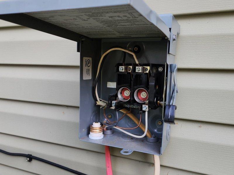 Responded to no-cool complaint on Goodman GSX130241FA condenser (approximately 5 years old, installed 2021-2022, single-phase R-410A system). Found outdoor unit repeatedly blowing 30-amp Edison fuses at disconnect; homeowner had previously replaced capacitor and installed hard start kit with no improvement. Diagnosed one compressor terminal leg electrically grounded to case, with active refrigerant leak detected at same terminal. Confirmed compressor failure requiring replacement and initiated warranty verification due to unit age.
