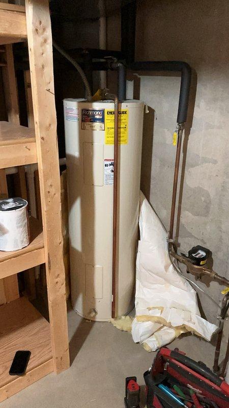 Responded to no hot water complaint at residence where occupant had recently moved in. Diagnosed electric water heater and confirmed 240V power supply present at unit. Testing revealed both thermostats had failed while heating elements tested within normal operating parameters. Presented repair options and proceeded with thermostat replacement on both upper and lower positions. Restored hot water functionality to unit.