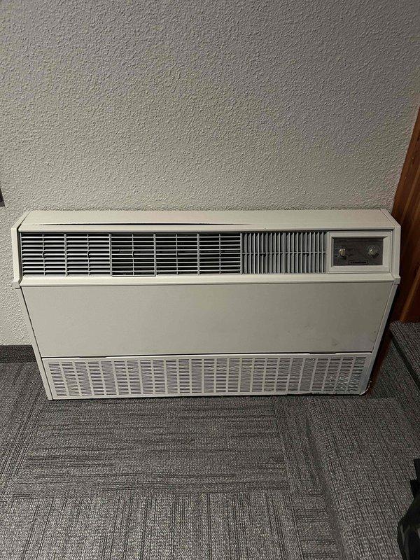 Responded to no-cool call on 15-year-old wall-mounted auxiliary HVAC unit in church sanctuary with complete power failure. Verified both building breakers were not tripped and cycled breakers with no restoration of power to unit. Tested capacitor which showed low readings on compressor side, though fan and compressor components appeared operational when checked. Determined electrical supply issue upstream of unit requires licensed electrician to diagnose and repair building wiring or circuit feeding the equipment before HVAC system can be restored to service.