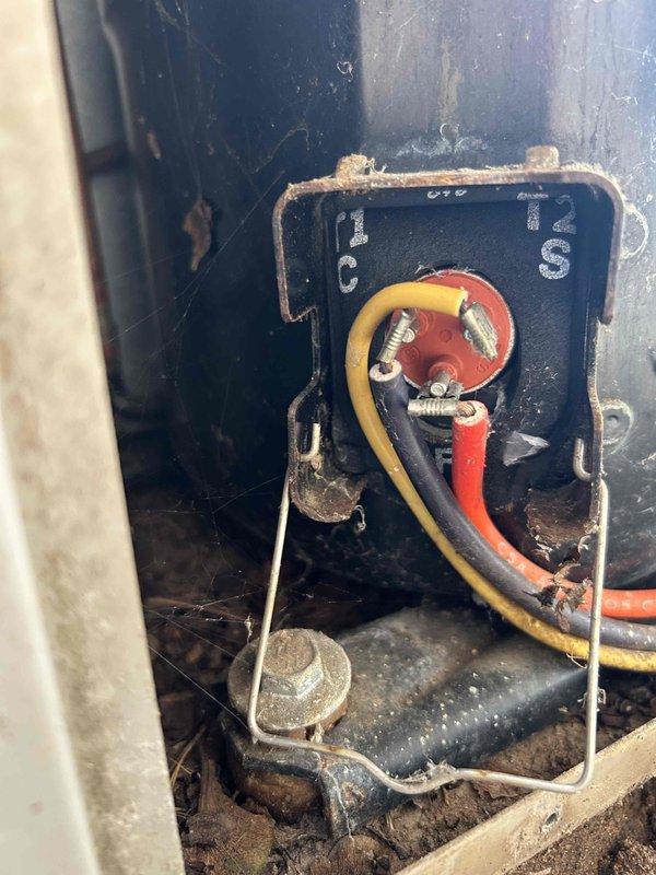 Responded to no-cool call on 15-year-old wall-mounted auxiliary HVAC unit in church sanctuary with complete power failure. Verified both building breakers were not tripped and cycled breakers with no restoration of power to unit. Tested capacitor which showed low readings on compressor side, though fan and compressor components appeared operational when checked. Determined electrical supply issue upstream of unit requires licensed electrician to diagnose and repair building wiring or circuit feeding the equipment before HVAC system can be restored to service.