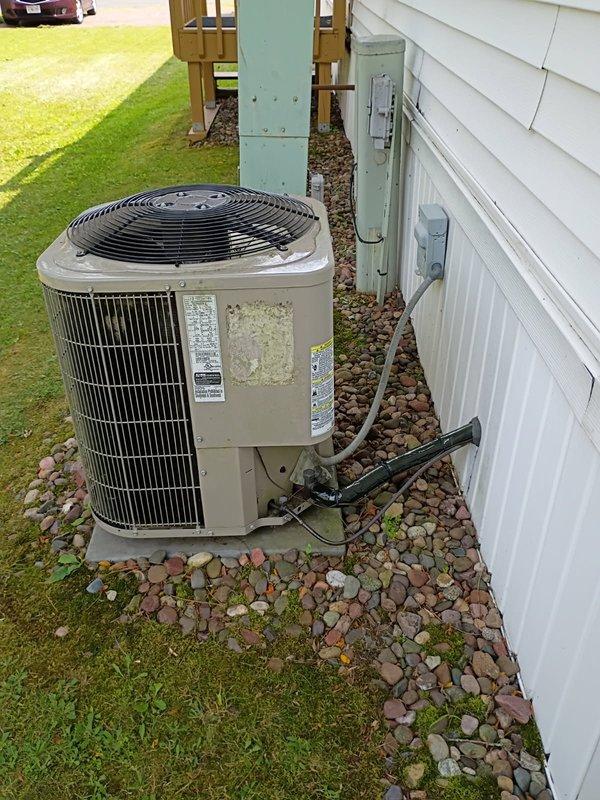 Responded to no cooling complaint on 11-year-old Bryant air conditioning system. Upon inspection, found unit low on R-410A refrigerant. Discovered liquid line at outdoor condenser unit had sustained physical damage with significant deformation to copper tubing, appearing as if something had fallen on or stepped on the line. Located active refrigerant leak at braze joint with visible oil residue, confirmed leak with soap bubble test. Provided estimate for repair including refrigerant recovery, disassembly and re-brazing of damaged fitting, nitrogen pressure test, vacuum procedure, and refrigerant recharge. Customer declined recommended repairs. Reassembled unit and departed premises.