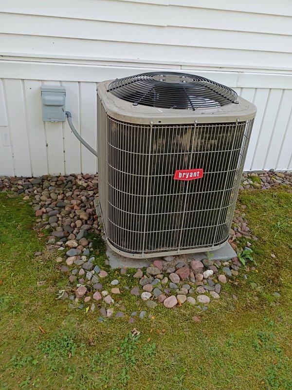 Responded to no cooling complaint on 11-year-old Bryant air conditioning system. Upon inspection, found unit low on R-410A refrigerant. Discovered liquid line at outdoor condenser unit had sustained physical damage with significant deformation to copper tubing, appearing as if something had fallen on or stepped on the line. Located active refrigerant leak at braze joint with visible oil residue, confirmed leak with soap bubble test. Provided estimate for repair including refrigerant recovery, disassembly and re-brazing of damaged fitting, nitrogen pressure test, vacuum procedure, and refrigerant recharge. Customer declined recommended repairs. Reassembled unit and departed premises.