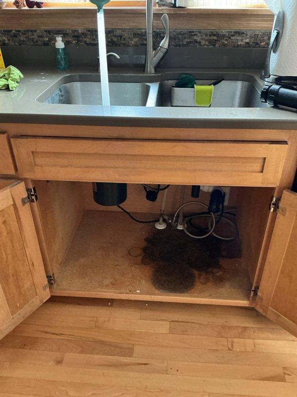 Responded to a kitchen sink stoppage with water backing up in the double-basin stainless steel sink. Upon inspection, determined the clog was located beyond the P-trap in the drain line. Additionally identified a leaking garbage disposal unit that required replacement.

Cabled the kitchen drain line to clear a grease blockage that had accumulated further down the system. Successfully restored proper drainage and flow through the line. Performed multiple fill-and-drain cycles to verify complete clearance and flush remaining debris from the drain system.

Removed the existing garbage disposal unit and installed a new replacement unit beneath the left sink basin. Connected all drain lines and verified secure mounting to the sink flange. Tested the new disposal for proper operation, confirming normal function without vibration or unusual noise. Inspected all connections for leaks while running water through both sink basins and operating the disposal unit. All plumbing connections remained