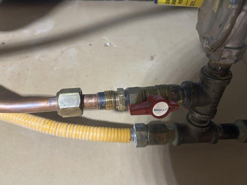 Returned to property to install gas shut-off valve in basement as previously sold. Installed new gas shut-off valve with red handle on main gas line, creating flared connection on top fitting to ensure proper seal. Upon completion, performed comprehensive leak testing on all connections using approved methods to verify system integrity. Successfully re-lit pilot lights for water heater and fireplace, confirming proper gas flow and safe operation of all appliances.