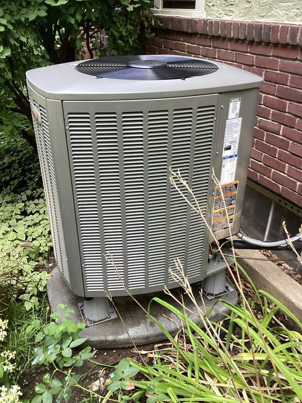 Completed Member A/C tune-up on outdoor condensing unit less than 10 years old. Performed comprehensive maintenance inspection of beige cylindrical condenser positioned on concrete pad adjacent to brick building. Unit showed no operational issues or deficiencies during inspection. All components including fan motor, compressor, and refrigerant lines functioning within normal parameters.