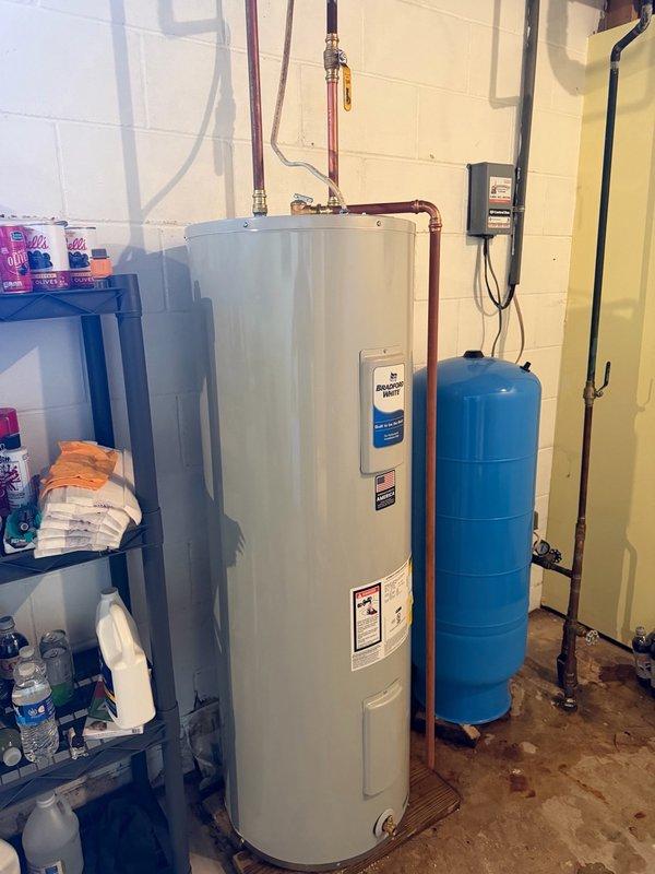 Responded to no hot water complaint and diagnosed electric water heater failure due to excessive sediment and calcium buildup in tank bottom. Removed existing non-functional unit and installed new Richmond brand electric water heater with 6-year warranty. Connected all copper supply lines, electrical wiring to panel box, and verified proper integration with existing blue pressure tank and water treatment system. Tested unit operation and confirmed hot water delivery restored to residence.