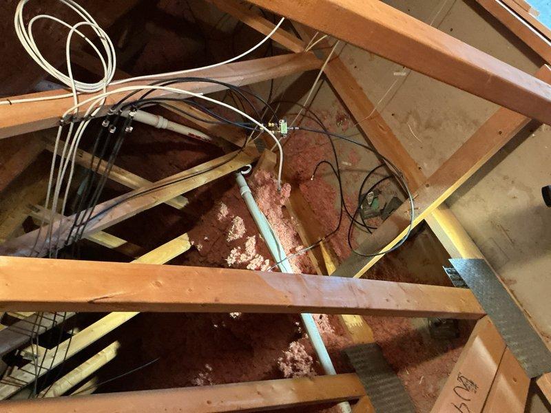Responded to emergency call for broken PVC vent pipe in attic. Upon inspection, discovered a 3-foot crack in the vent pipe caused by freezing conditions after roofing contractors improperly pushed the pipe down during previous roof work. The damaged pipe ran from the attic through the laundry room and back out through the roof. Removed and replaced the compromised section of PVC piping, restoring proper ventilation system function. Documented conditions with photos showing the attic workspace, insulation, existing pipe routing, and structural components for record purposes.